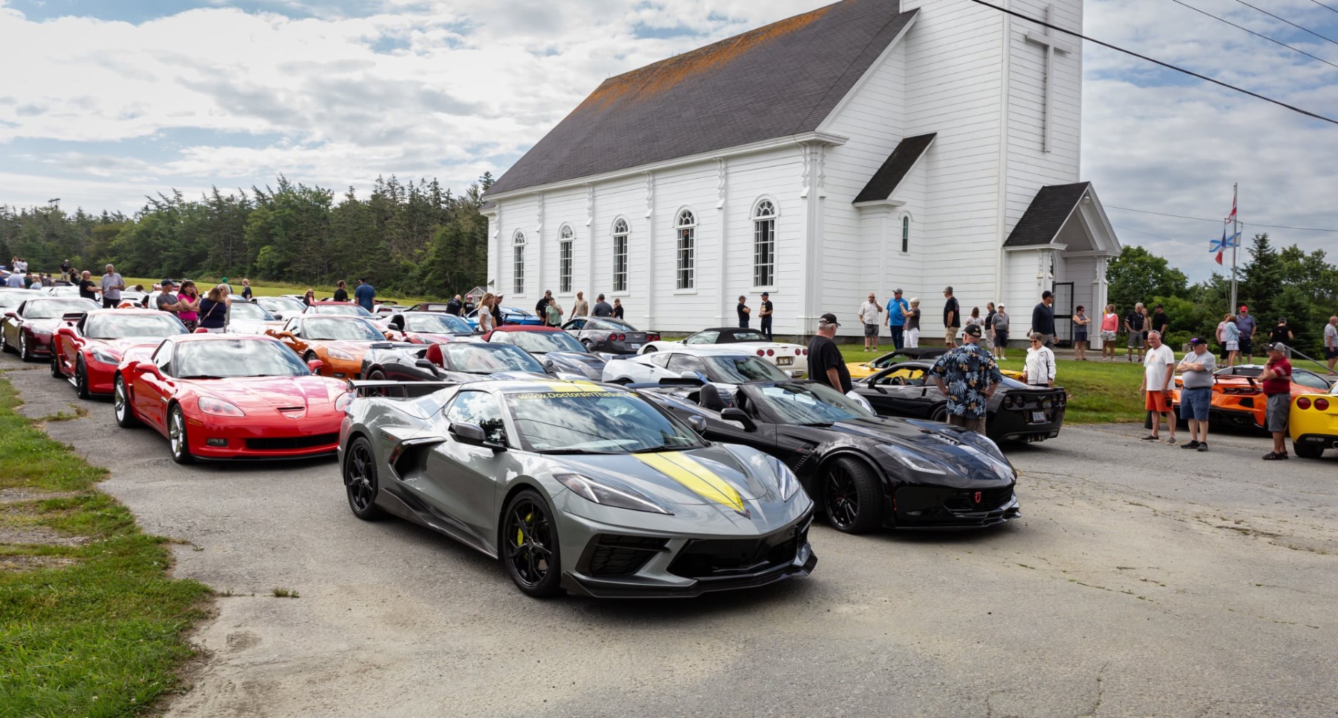 Corvettes lined up at a white church in Nova Scotia